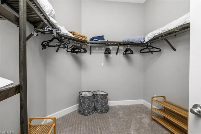 a view of walk in closet with clothes and shoes