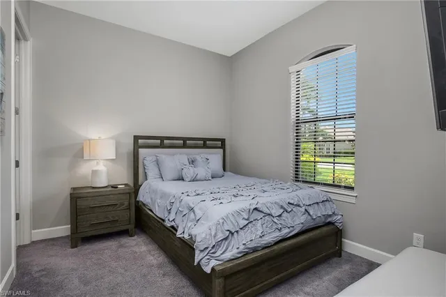 a bedroom with a bed a window and a mirror