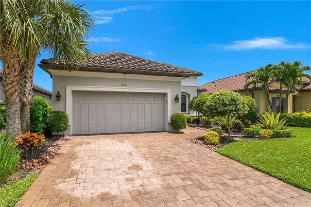 a view of a house with a yard and palm trees