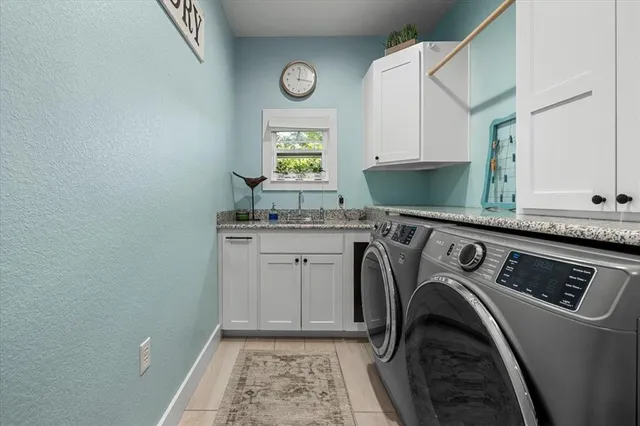 a utility room with cabinets washer and dryer