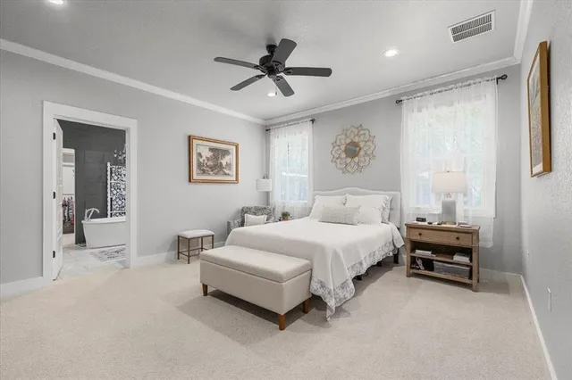 a spacious bedroom with a bed and ceiling fan