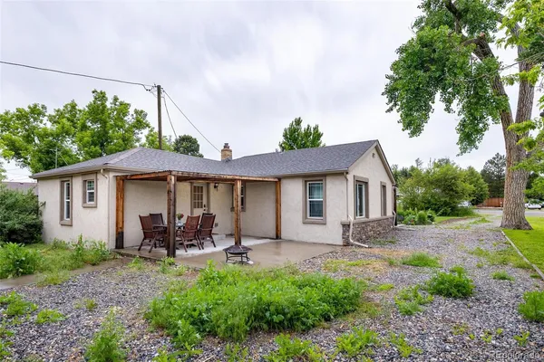 a backyard of a house with table and chairs