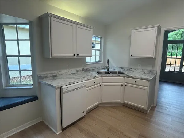 a kitchen with granite countertop white cabinets and white appliances