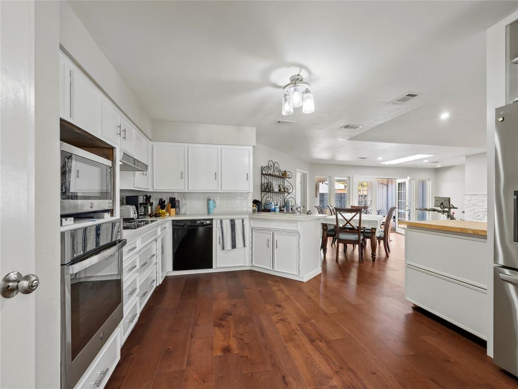 4707 Harvest Hill Road Dallas, TX 75244 - Photo 9 of 20 a kitchen with a refrigerator and a stove top oven