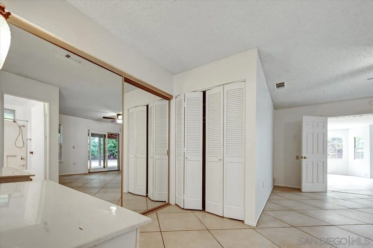 27335 Ventan Street Menifee, CA 92586 - Photo 28 of 36 a view of a hallway with wooden floor and a bathroom