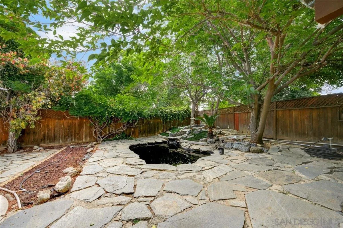 27335 Ventan Street Menifee, CA 92586 - Photo 31 of 36 a view of backyard with a table and chairs and wooden fence