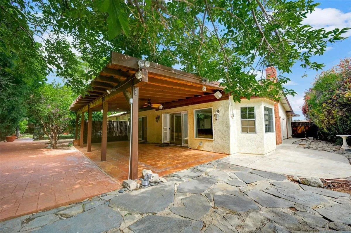 27335 Ventan Street Menifee, CA 92586 - Photo 33 of 36 a patio with a table and chairs and a large tree