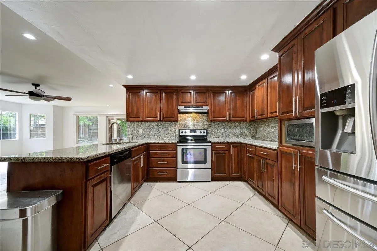 27335 Ventan Street Menifee, CA 92586 - Photo 10 of 36 a large kitchen with stainless steel appliances granite countertop a stove sink and cabinets