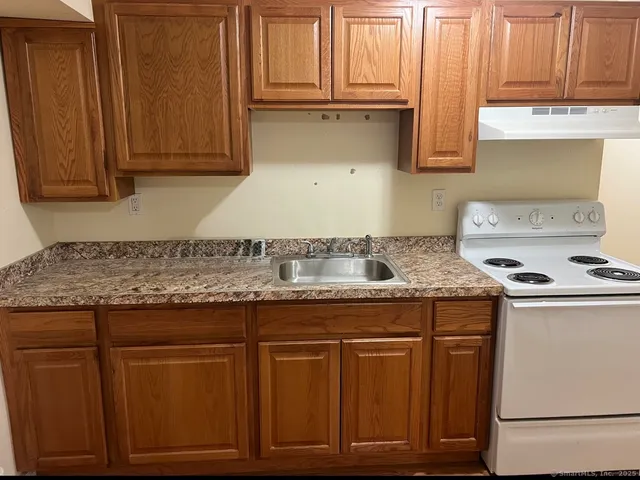 a kitchen with granite countertop cabinets and white appliances