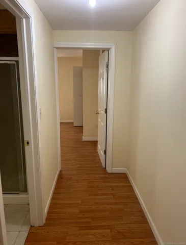 a view of a hallway with wooden floor
