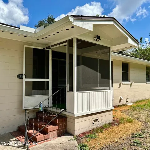 a view of a house with a small yard and wooden floor and fence