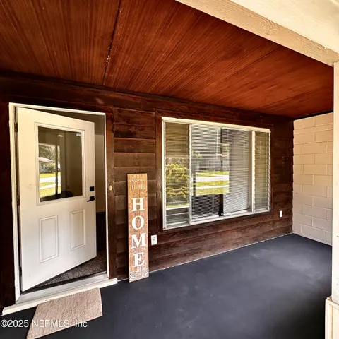 a view of a room with wooden floor and windows