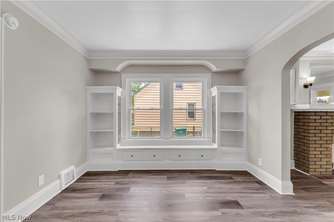 18123 McCracken Road Maple Heights, OH 44137 - Photo 7 of 27 Built-in window seat with integrated storage drawers framed by custom shelving, wood-finish flooring, and crown molding accents