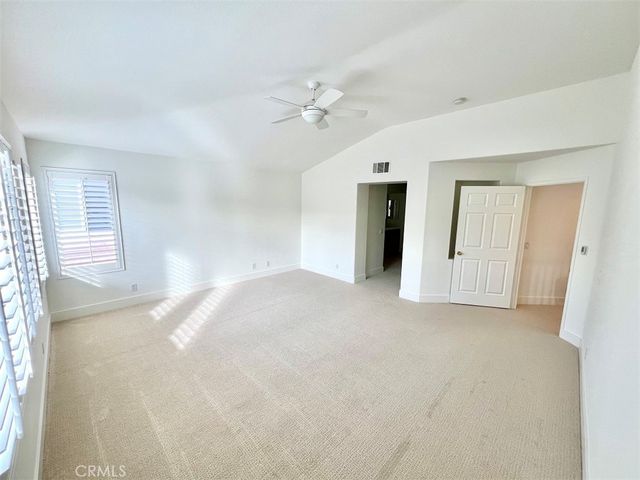a view of a big room with windows and chandelier fan