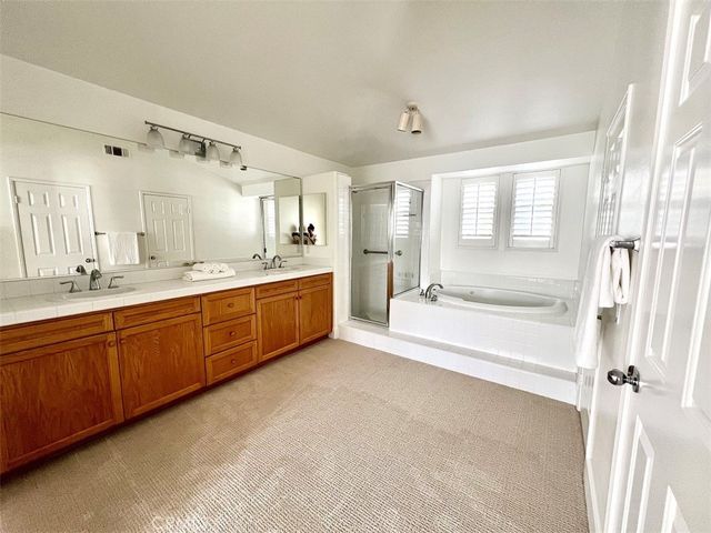 a spacious bathroom with a tub sink shower and mirror