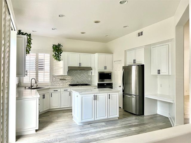 a kitchen with stainless steel appliances a refrigerator sink and microwave