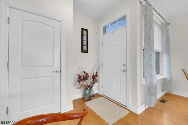 a kitchen with stainless steel appliances granite countertop a refrigerator a stove a sink dishwasher a oven with white cabinets and wooden floor