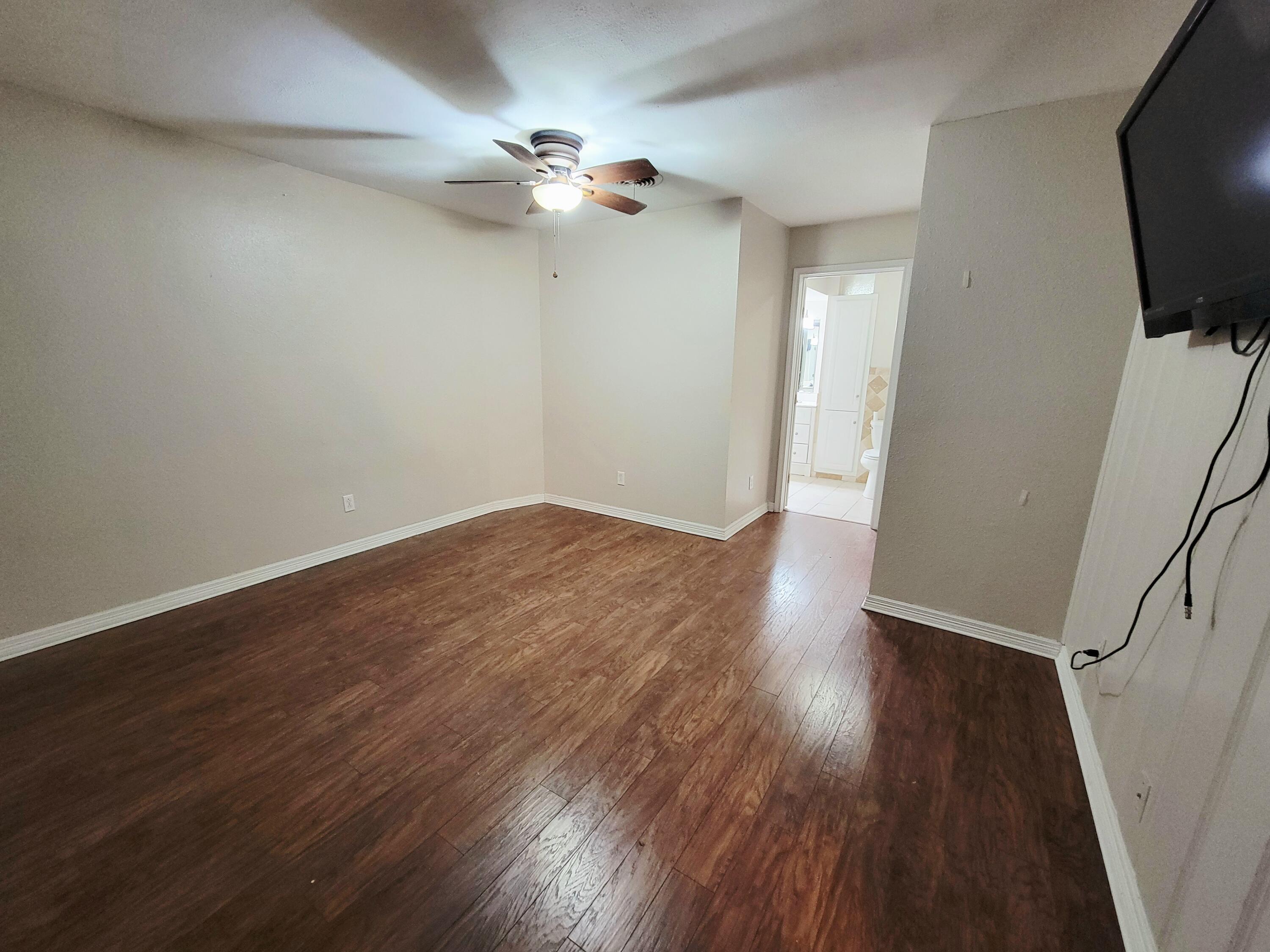 3408 38th Street Lubbock, TX 79413 - Photo 12 of 18 wooden floor in an empty room with a window