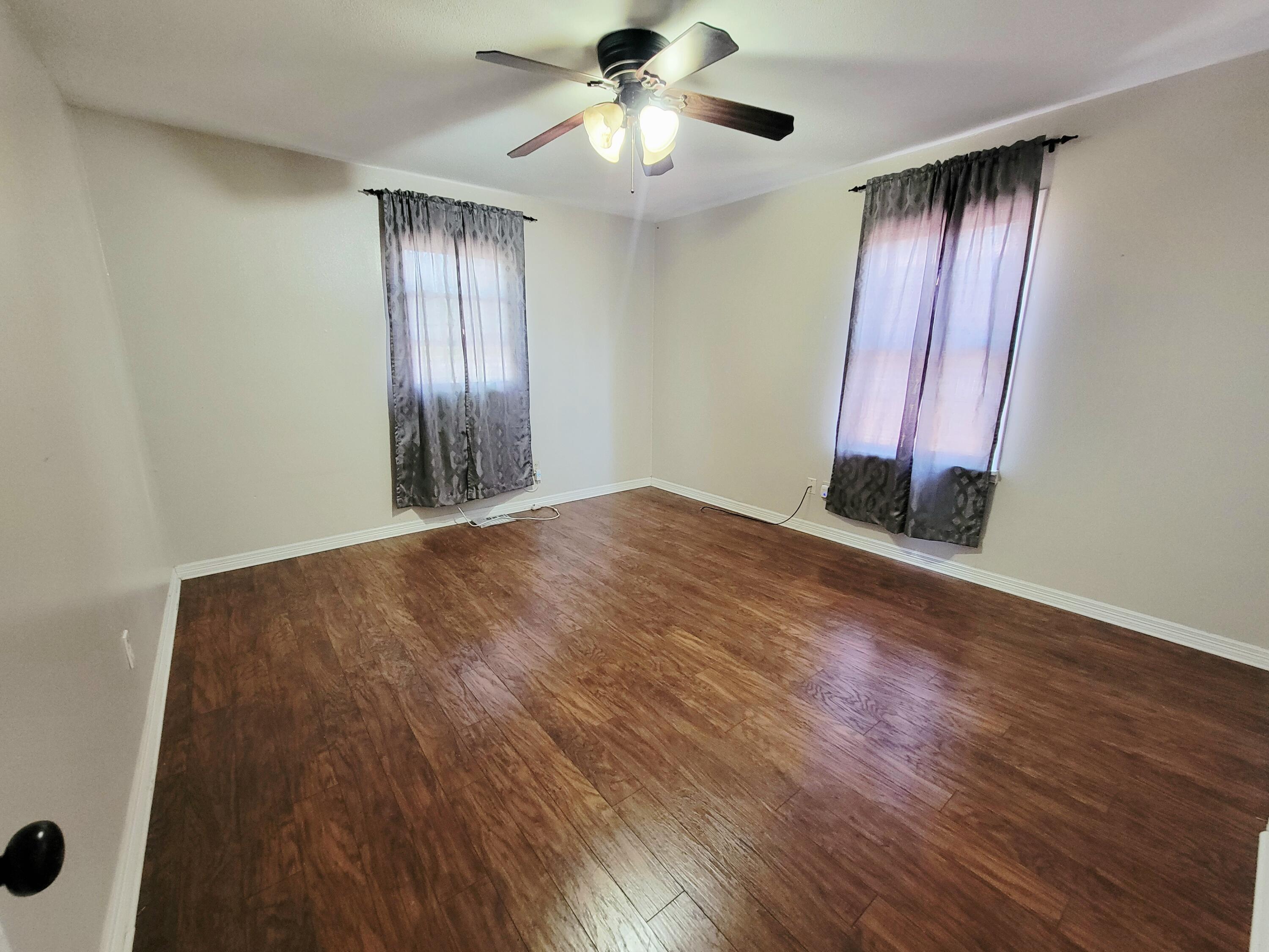 3408 38th Street Lubbock, TX 79413 - Photo 14 of 18 wooden floor in an empty room with a window