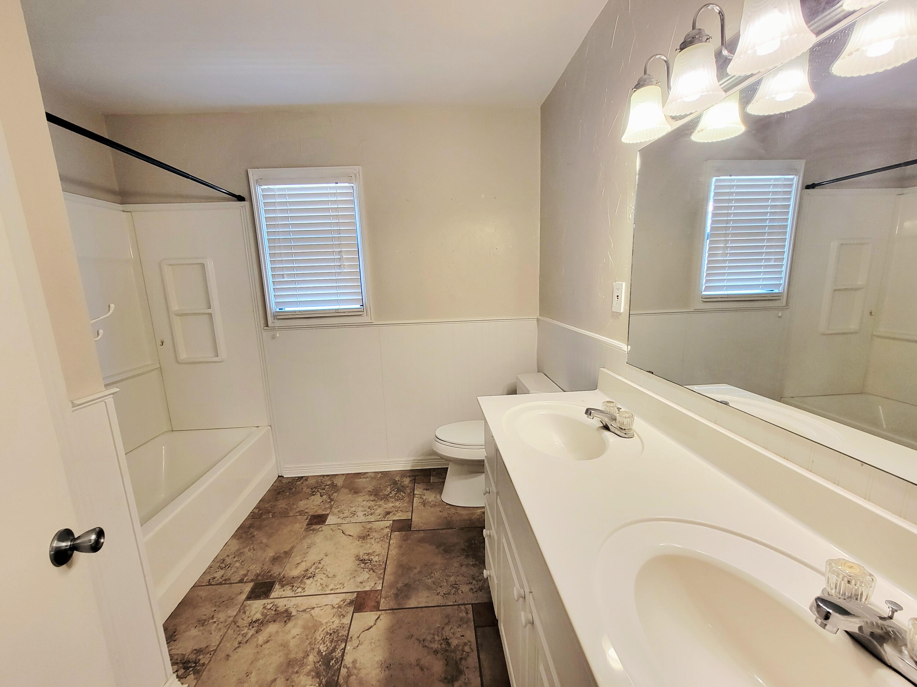 3408 38th Street Lubbock, TX 79413 - Photo 15 of 18 a bathroom with a sink a vanity and shower