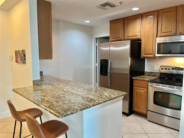 a kitchen with stainless steel appliances granite countertop a stove refrigerator sink and microwave