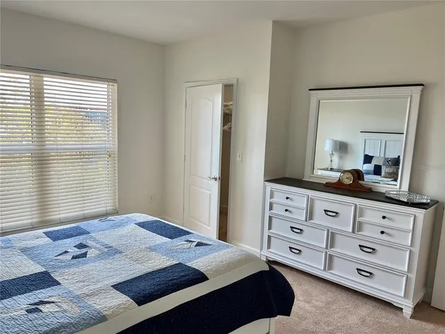 a bedroom with a bed a dresser and a window