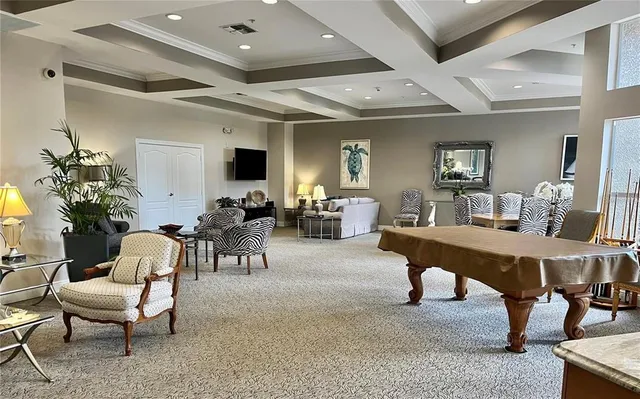a living room with furniture a chandelier and a dining table with wooden floor