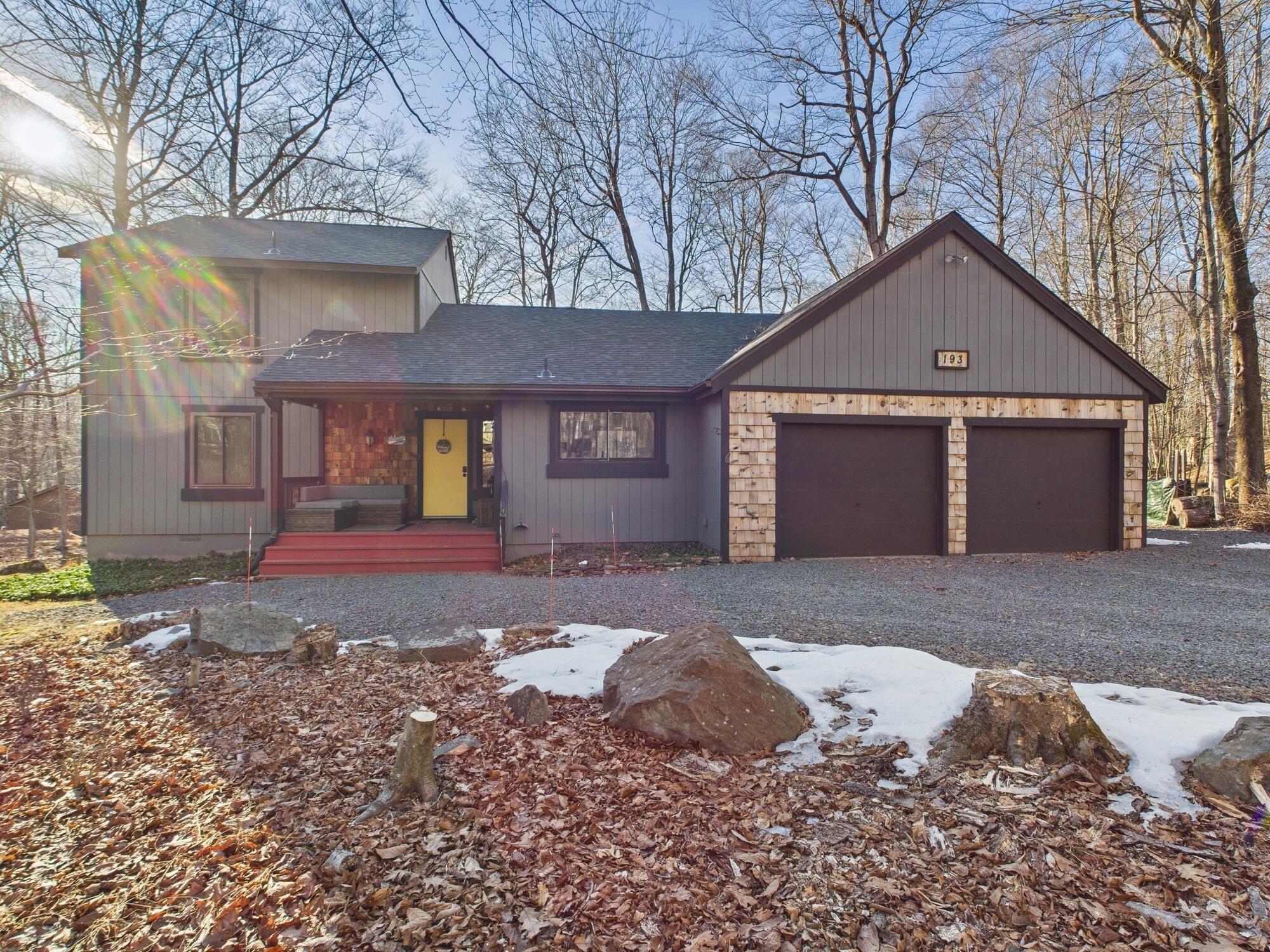193 Elk Run Road Pocono Lake, PA 18347 - Photo 2 of 51 a front view of a house with a yard and garage