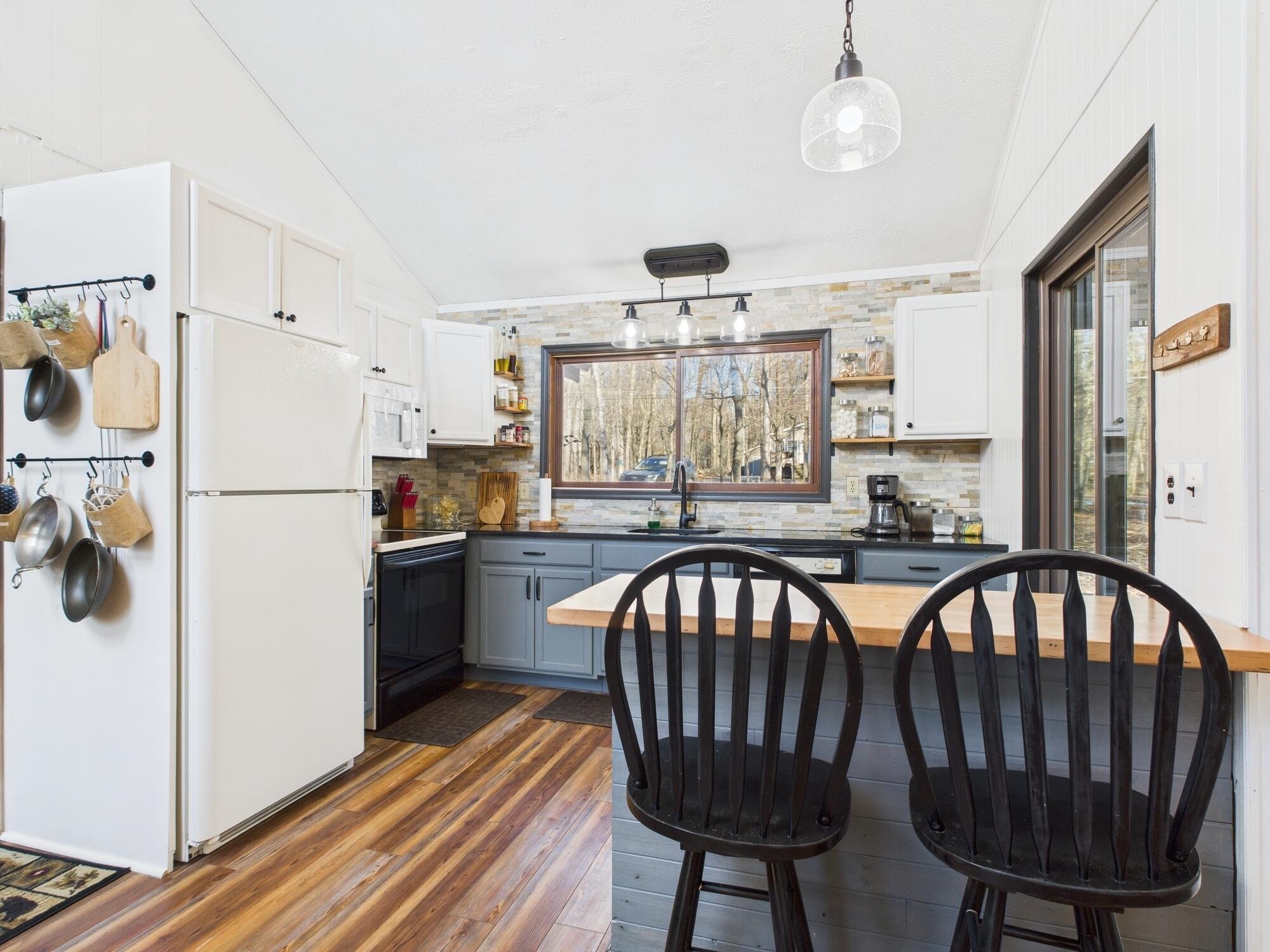 193 Elk Run Road Pocono Lake, PA 18347 - Photo 6 of 51 a kitchen with stainless steel appliances granite countertop a refrigerator a sink a stove a dining table and chairs