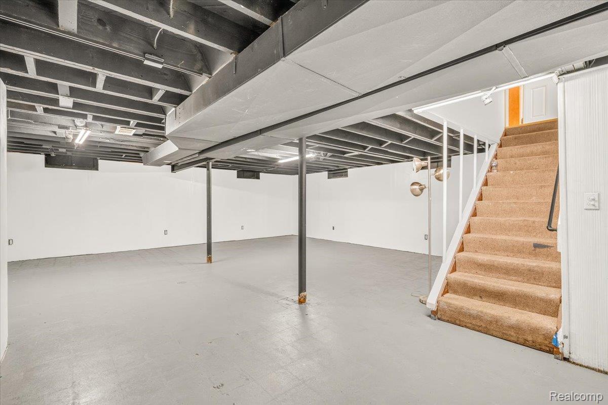 11802 Columbia Street Redford, MI 48239 - Photo 22 of 39 Expansive finished lower level featuring finished concrete flooring, drywall, and a painted exposed ceiling with overhead lighting.