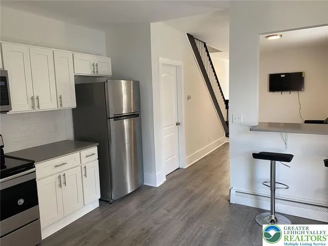 a kitchen with a refrigerator and a stove top oven