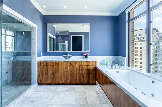 a bathroom with a tub a sink and mirror