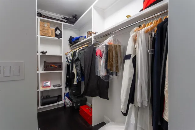 a view of walk in closet with clothes and shoes