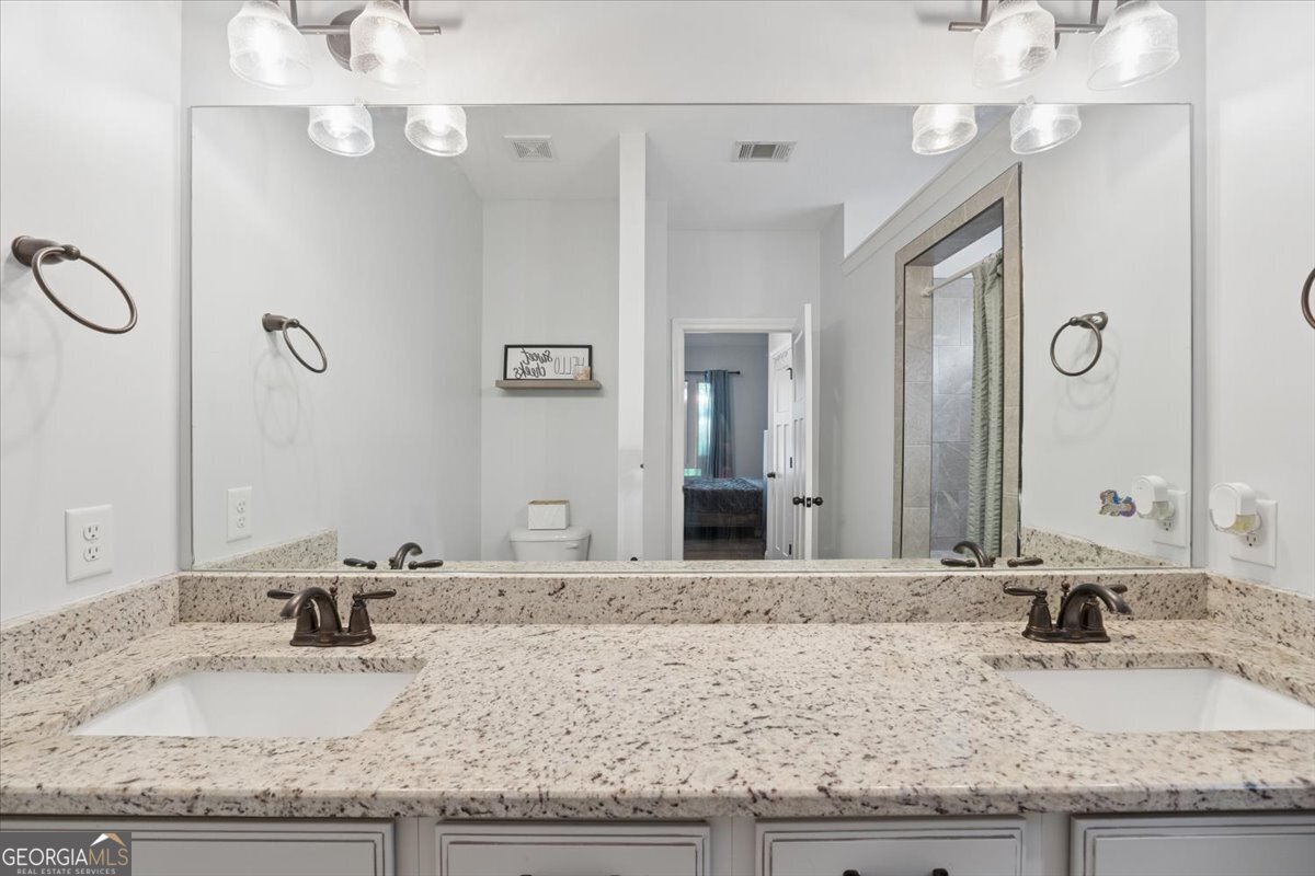 683 Teagle Road Forsyth, GA 31029 - Photo 26 of 50 a bathroom with a granite countertop sink and a mirror