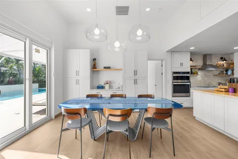 a kitchen with stainless steel appliances kitchen island granite countertop a stove a sink a dining table and chairs