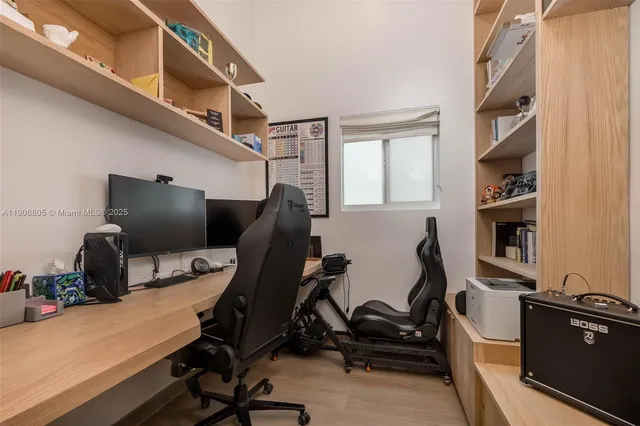 a view of a workspace with furniture and a window