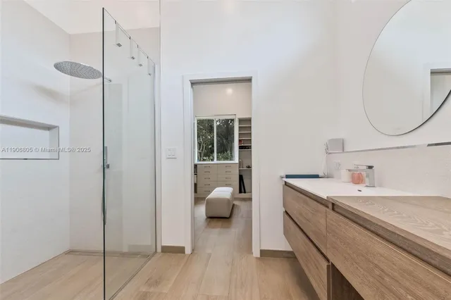 a en suite bathroom with a granite countertop sink and a mirror