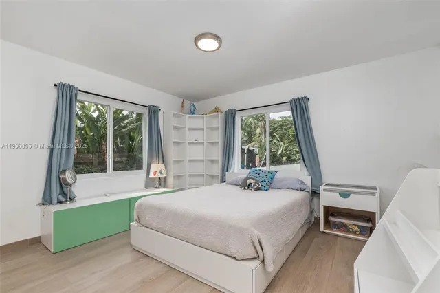 a bedroom with a bed and a large window