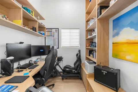 a view of a workspace with furniture and a window