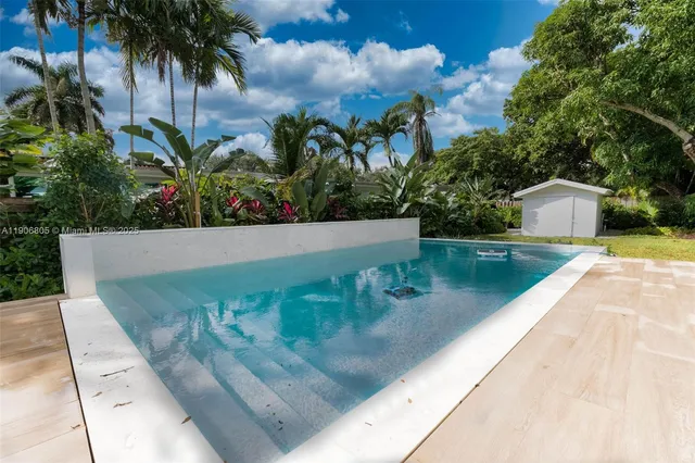 swimming pool view with a garden space