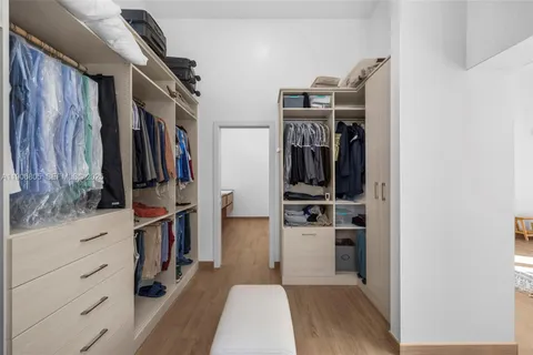 a view of walk in closet with clothes and shoes