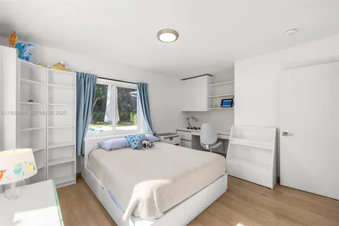 a bedroom with a bed and large window