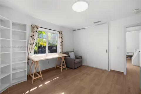 a view of workspace and bedroom with furniture and a window