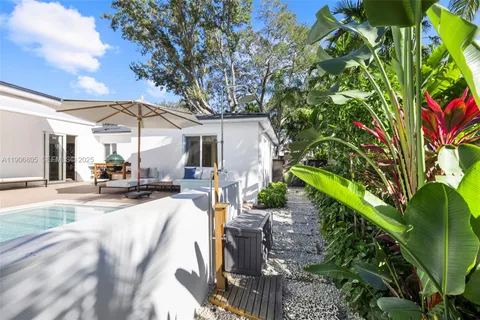 a view of a backyard with couches under an umbrella