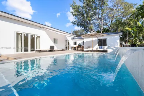 a view of a house with pool and chairs