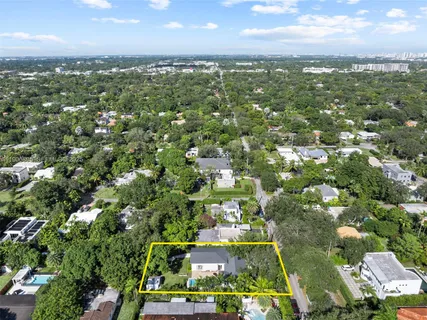 an aerial view of residential houses with outdoor space and trees