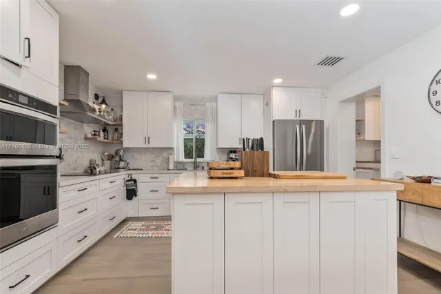 a kitchen with stainless steel appliances kitchen island granite countertop a sink and cabinets