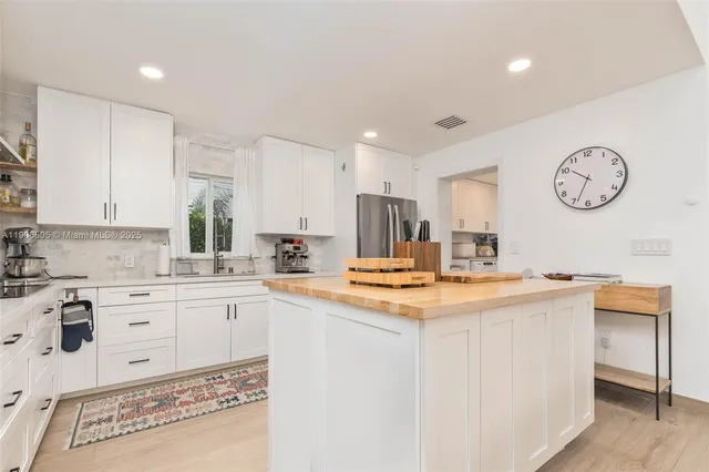 a kitchen with kitchen island a stove a sink and a refrigerator with wooden floor