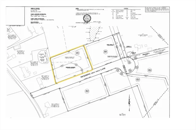 a view of a yard with plants and a building