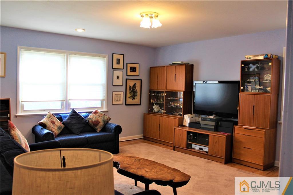 23 Clive Hills Road Edison, NJ 08820 - Photo 17 of 25 a living room with furniture a flat screen tv and a window